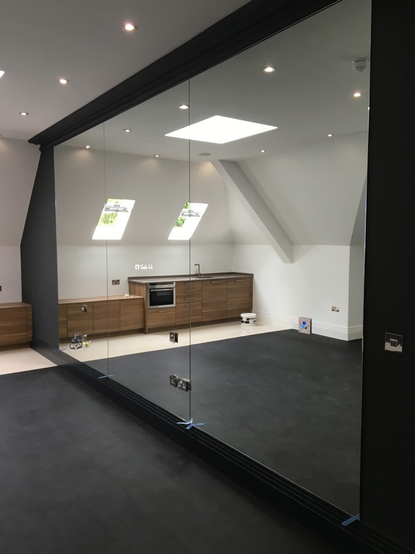 Frameless glass partition in loft conversion by Woolwich glaziers