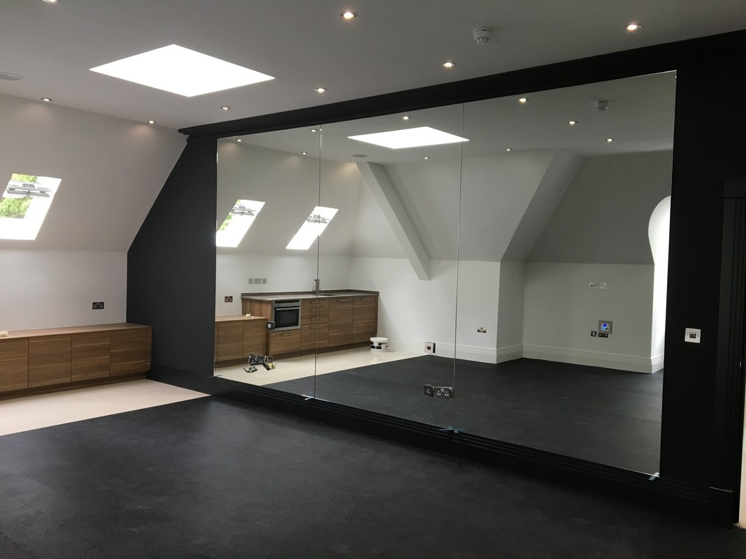 Frameless glass wall dividing loft conversion in Woolwich